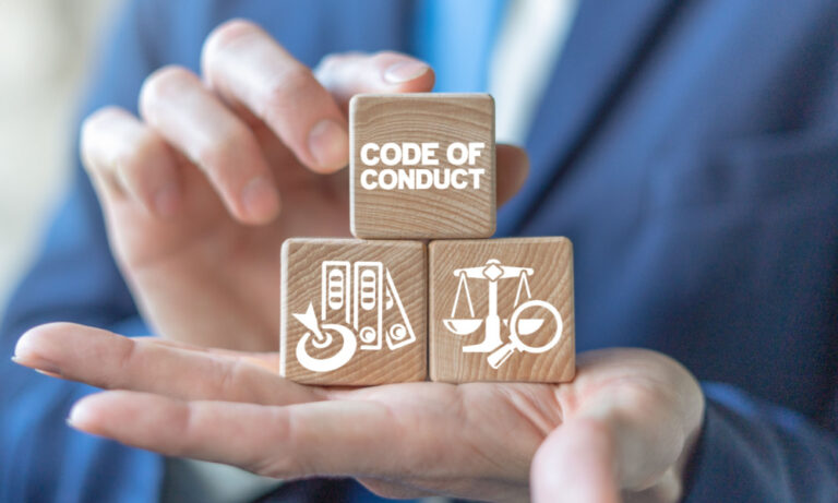 Man holding wooden blocks with words "Code of Conduct"